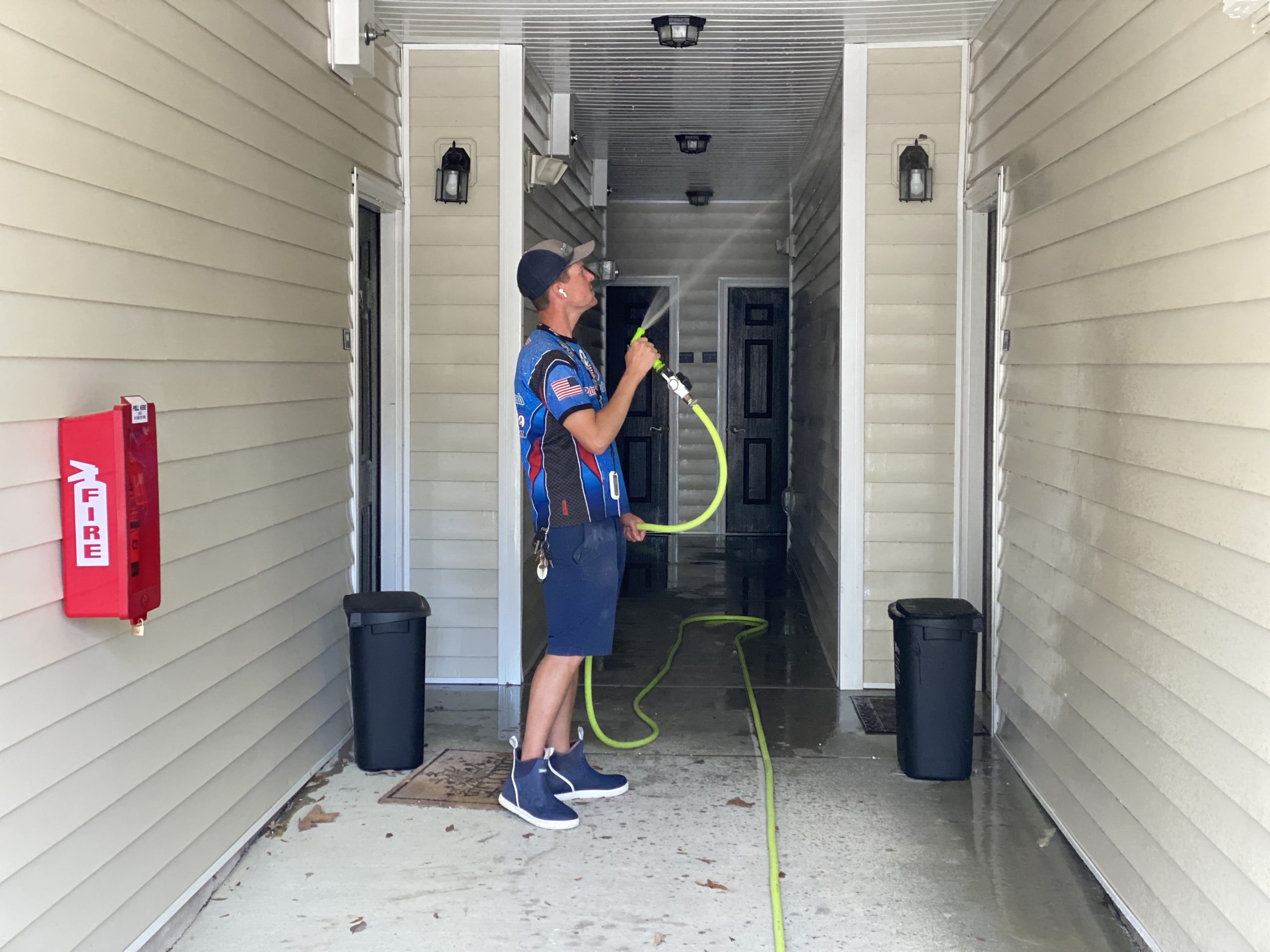 Patriot Softwash technician soft washing an apartment breezeway in Raleigh, NC