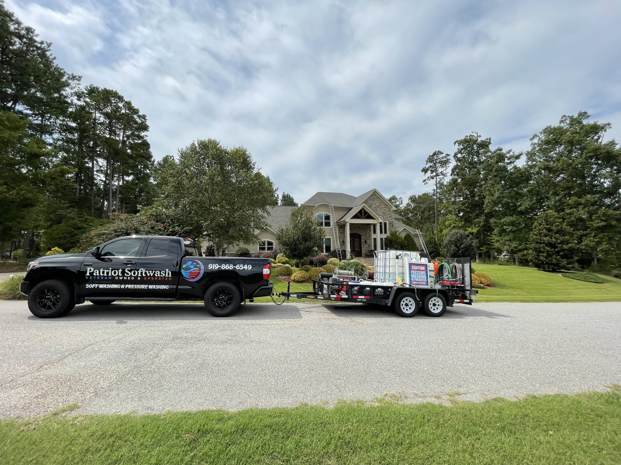 Patriot Softwash truck outside a Clayton home after roof cleaning and house washing